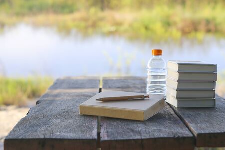 Old book with pencil, in the park.  green nature backgroundの写真素材