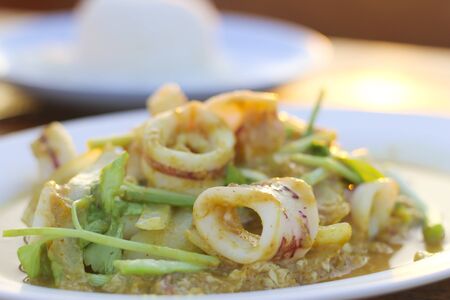 Fried Squid curry powder isolated on Sunset light background.