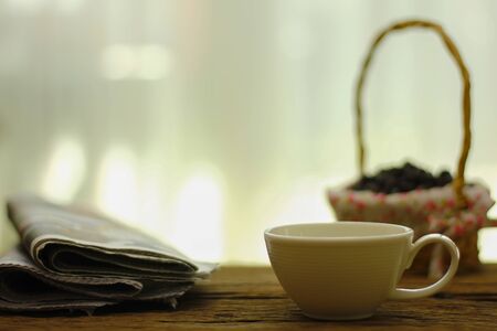 Close up Coffee cup and newspaper on the table in the morningの写真素材