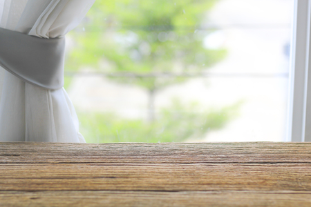 Empty wooden table top with blur with bokeh background near windoorの写真素材