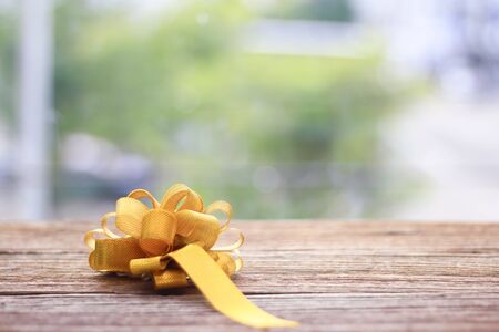 gold gift bow Texture on wooden table on green backgronudの写真素材