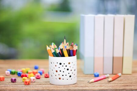 Cup with colorful Pencils on wooden table