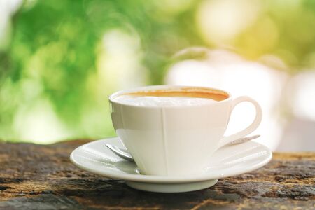 A cup of hot cappuccino on table at outdoor on brown old wooden tableの写真素材
