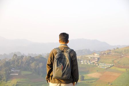 Carefree Happy man Enjoying Nature on grass meadow on top of mountain.Freedom concept. Len flare effect. Sunbeams. Enjoyment.の写真素材