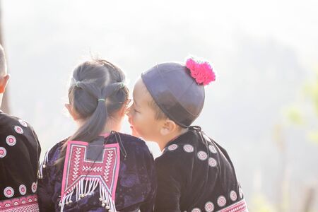 Lovely boy and girl playing outdoors while posing wearing ethnic clothes from the Hmong tribe, indigenous people of Thailand.のeditorial素材