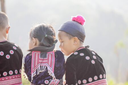 Lovely boy and girl playing outdoors while posing wearing ethnic clothes from the Hmong tribe, indigenous people of Thailand.のeditorial素材