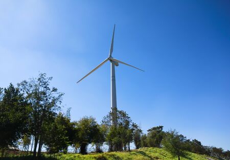 Wind turbine renewable energy source summer landscape with clear blue sky and field in the...