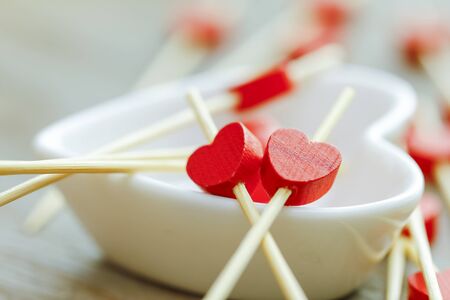 Red wooden heart on white Heart Cup with boke background.