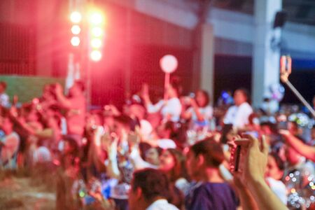 Blurry colorful background of hand holding smart phone to taking memories. people holding smart phones and photographing Taking photo on front stage in entertainmentの写真素材