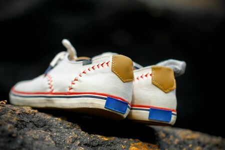 Selfie of sneakers resting on a rock on black backgroundの写真素材