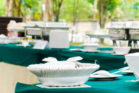 Set of white spoons organised on white plate on table . A set of plates gathered together. Household...