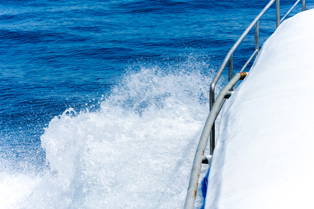Trail on water surface beside of fast moving motor boatの写真素材