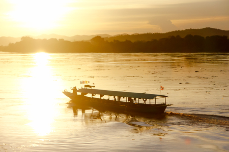 Enjoying the best sunset on river. Side view of passenger boat  on river with sunset in the backgroundの写真素材