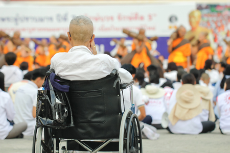 Elderly people ride wheelchair to pay homage to bless.の写真素材