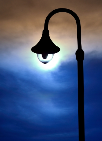 silhouette street lamps on evening skyの写真素材