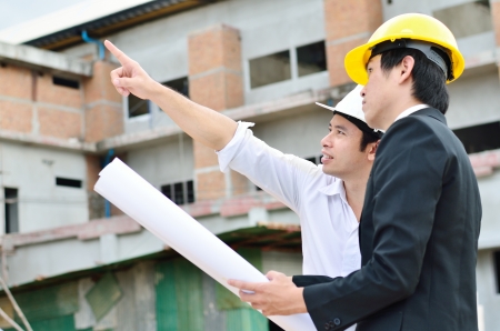 Two engineers are working on a construction areaの写真素材