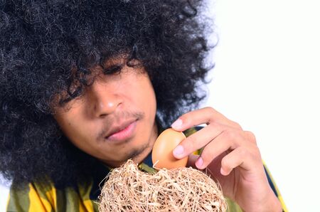 funny man take care egg in nest as Security and Safety conceptの写真素材