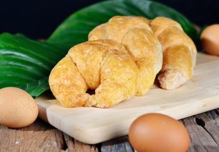 fresh french croissant with eggs on wood backgroundの写真素材
