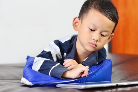 Close up a boy playing a game on computer tabletの写真素材