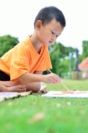 Going back to school  Cloe up Boy drawing and painting over green grass backgroundの写真素材