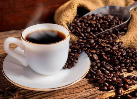 Hot coffee with cup and coffee bean bag on old wood background vintage styleの写真素材