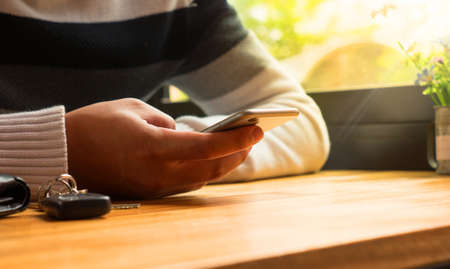 Businessman use application with smartphone for payment and check money online at coffee shop and sunligh environmentの写真素材