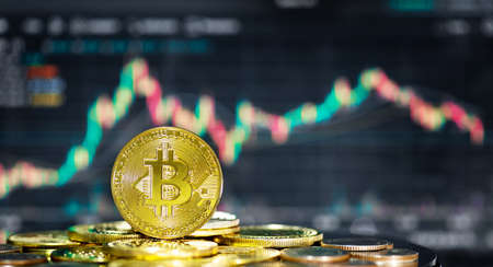 The golden bitcoin coin sits on a stack of cryptocurrencies over trade graph background