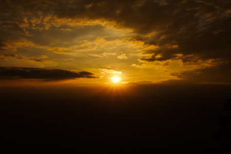 Sunset over the mountains There were dark clouds surrounding the sun , golden sun rays , Phu...