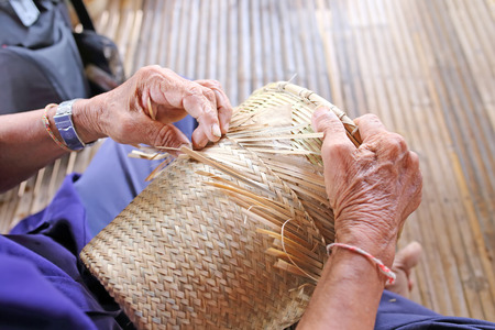 manually weaving bamboo basket in Thailandの写真素材