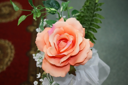 Beautiful artificial pink rose with green leaves and decorationsの写真素材