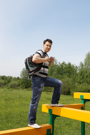 Young man with backpack at playground at summer day outdoors. の写真素材