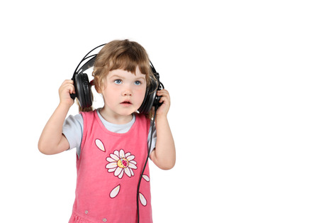 Little cute girl listens to music in big headphones isolated on white background.の写真素材