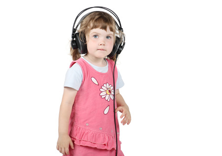 Little girl in big headphones looks at camera isolated on white background.の写真素材
