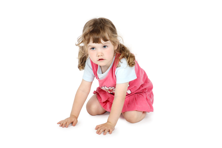 Little pretty girl crawls on floor isolated on white background.の写真素材