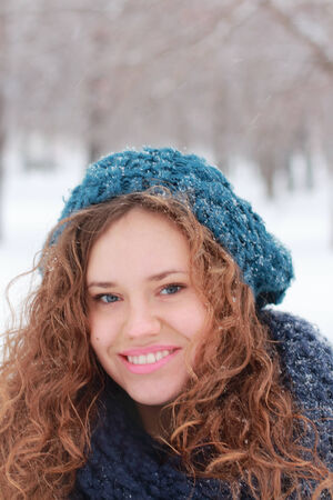 Pretty girl in blue beret smiles outdoor at winter day in parkの写真素材