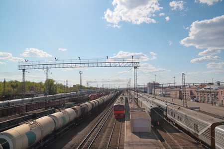 long passenger and freight trains at railway station at spring dayの写真素材