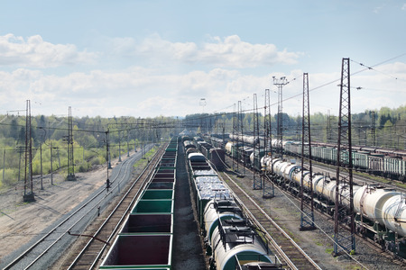 long freight trains at railway station with many wires at summer dayの写真素材