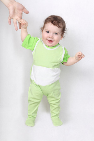 Happy baby making first steps holding father handの写真素材