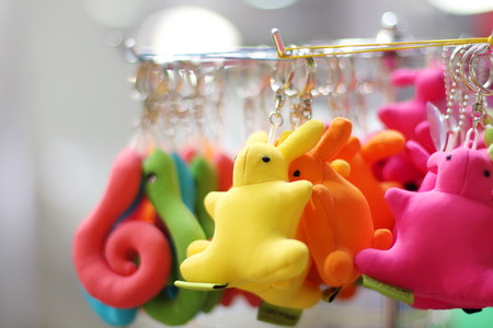 Small soft multicolored bunnies and snakes keychains hang in shop. Shallow dofの写真素材