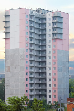 Unfinished high-rise apartment building with pink and white wallsのeditorial素材