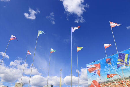 PERM, RUSSIA - JUNE 25, 2014: Triangular flags of different countries on background of blue sky at...