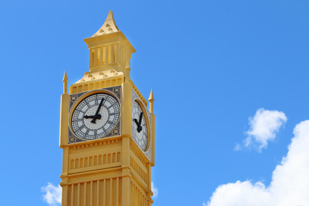 Yellow layout of Big Ben tower on blue sky background on sunny day closeup