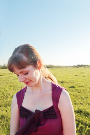 Closeup beautiful smiling girl in meadow in sunny summer dayの写真素材
