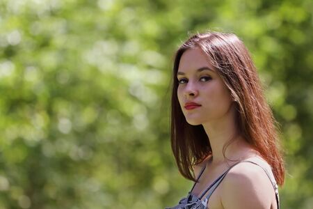 Closeup of beautiful girl in dress, looking to camera with shallow depth of fieldの写真素材