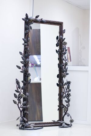 Wrought frame twined with roses with mirror in white roomの写真素材