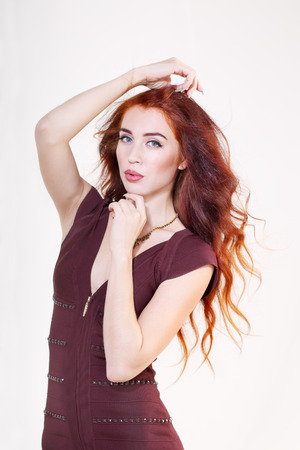 Closeup beautiful young girl with red hair and brown summer dressの写真素材