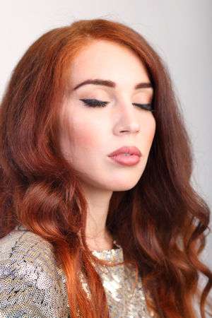 Portrait beautiful young girl with red hair with closed eyes in studioの写真素材