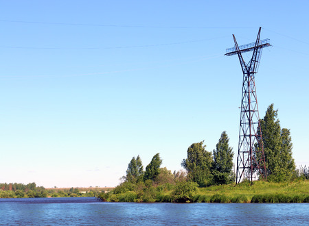 River coast line with green fresh grass and power transmission line at summer dayの写真素材
