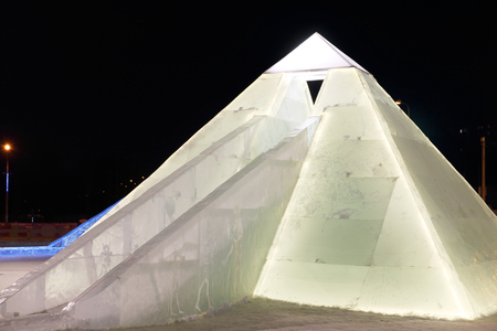 PERM, RUSSIA - JAN 26, 2015: Ice illuminated sculpture Egyptian pyramid with slide in Ice townのeditorial素材