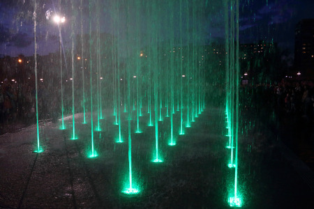 Beautiful dry fountain with green illumination at night in cityの写真素材